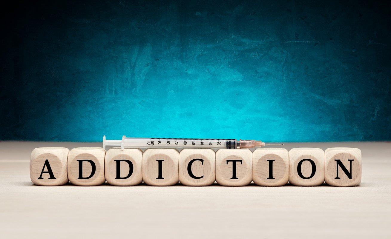 The word addiction on wooden cubes with syringe. Drug or substance addiction concept. The Frontline in the Fight Against Addiction